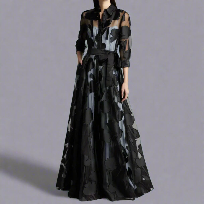 Woman wearing a long lightweight black maxi dress with a fluid silhouette and elegant drape