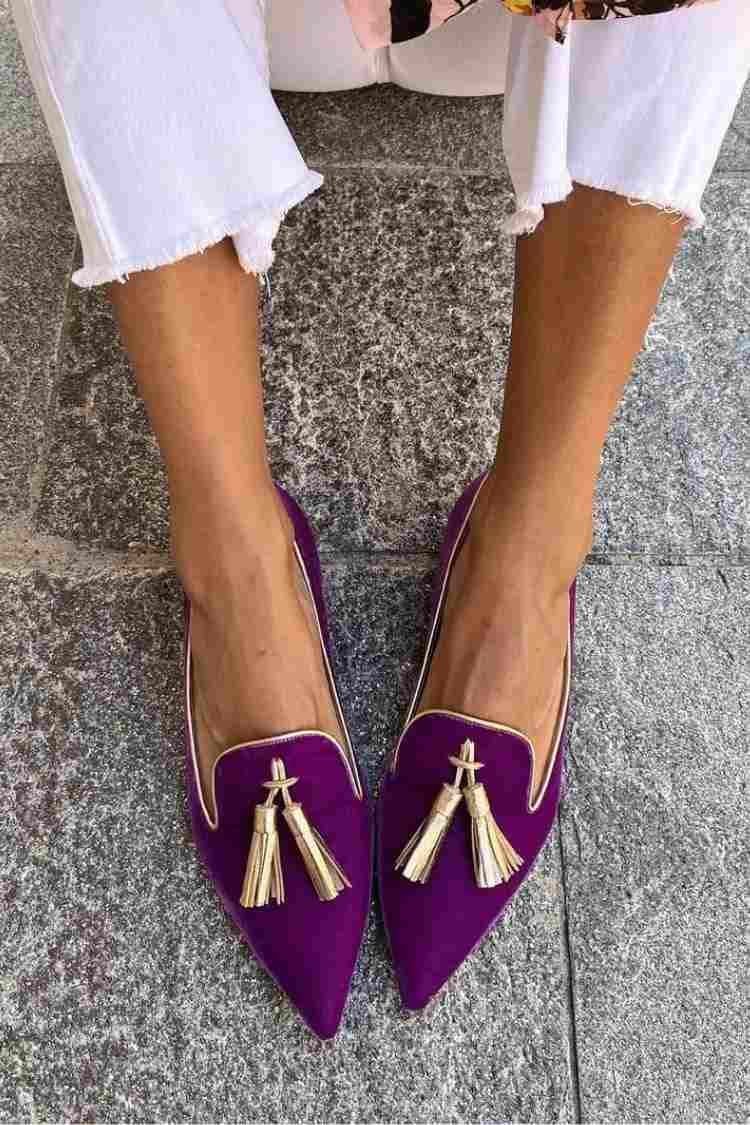 Pair of Denise tassel loafers in black styled flat lay on a neutral background