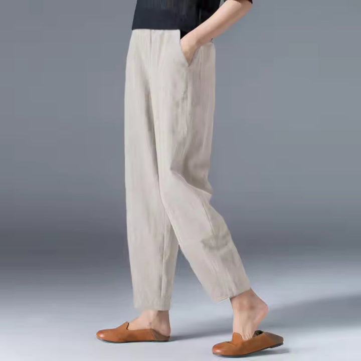 Burgundy lightweight summer trousers laid flat showing fabric texture and elastic waistband