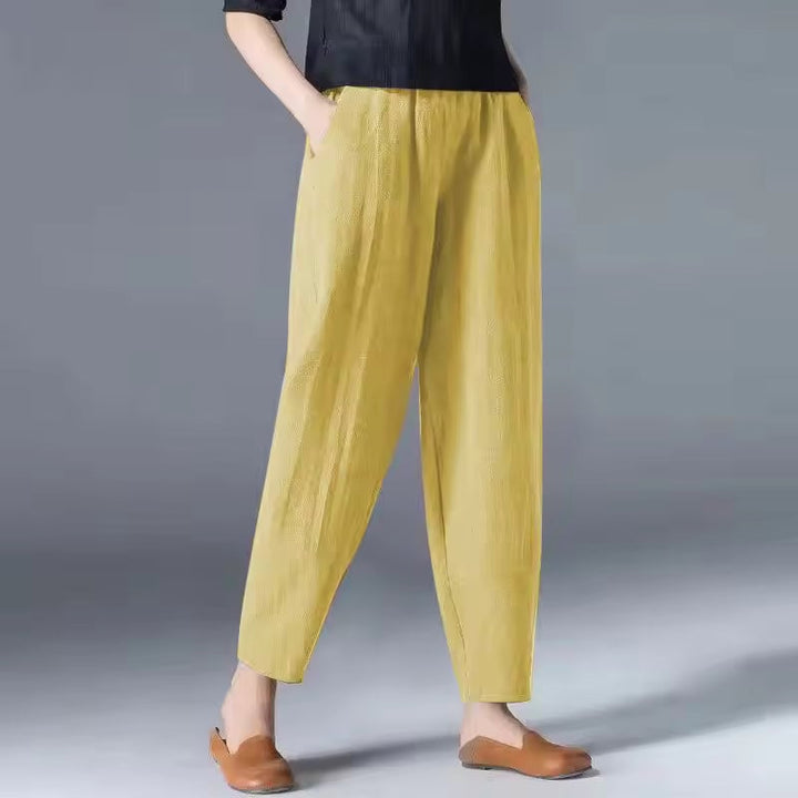 Woman wearing white relaxed-fit summer trousers styled with a flowy blouse for a coastal look