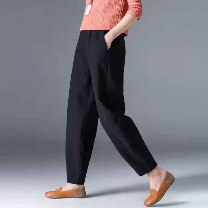 Dark blue lightweight ankle trousers on a woman showing the easy, breathable silhouette
