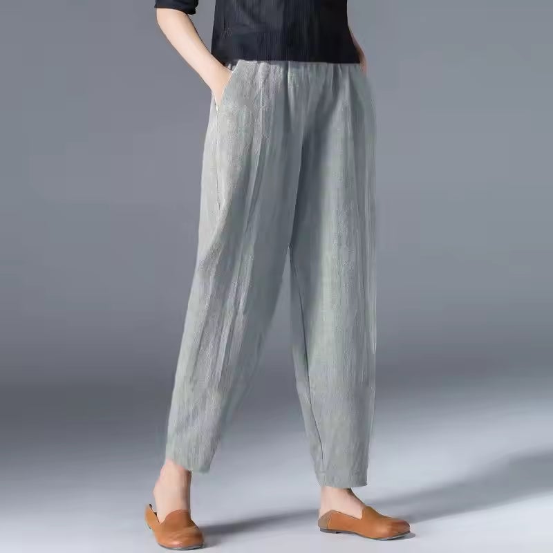 Woman packing lightweight summer trousers into a travel bag, demonstrating the travel-ready design
