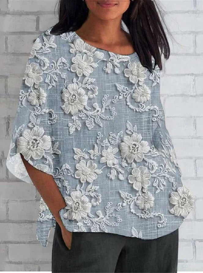 Close-up detail of delicate floral embroidery on a lightweight relaxed blouse in blue