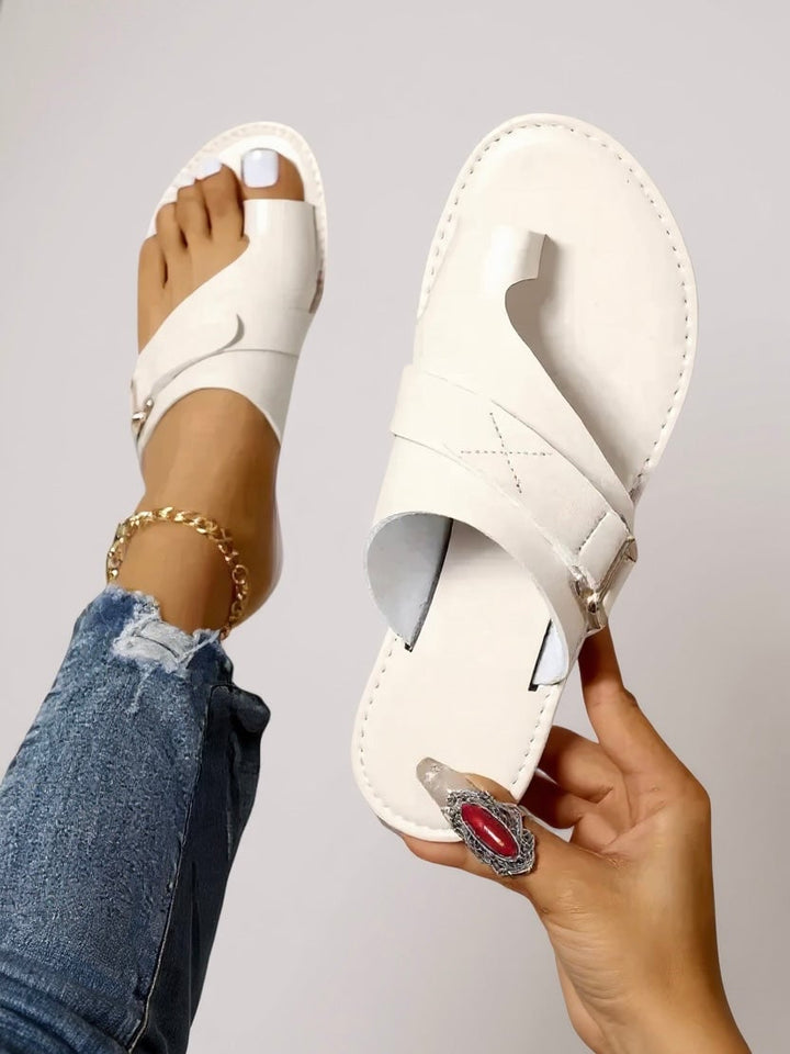 Close-up of the Diana toe-loop slides showing the sleek toe-loop detail and flexible sole in white