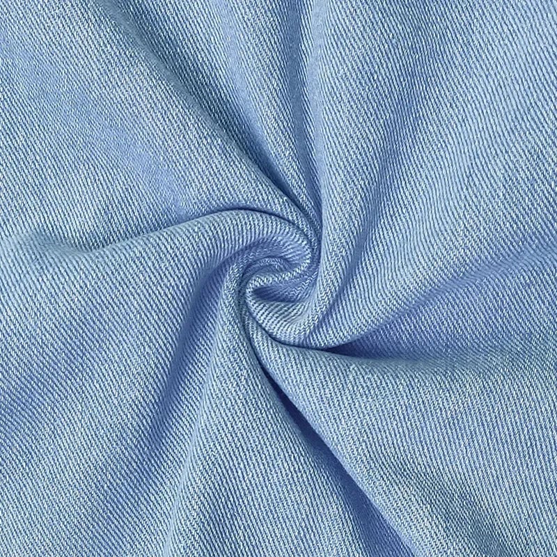 Close-up detail of the Dolores blue denim dress showing pocket placement and fabric texture