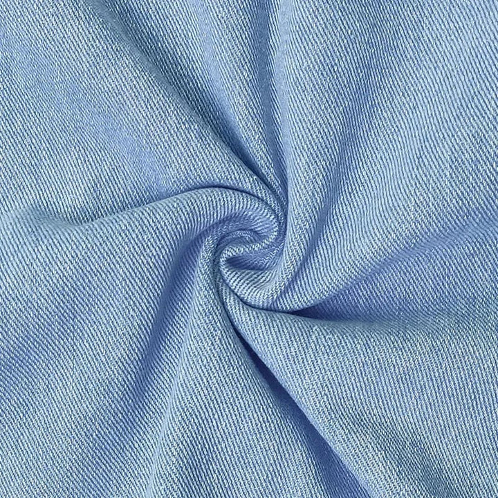 Close-up detail of the Dolores blue denim dress showing pocket placement and fabric texture