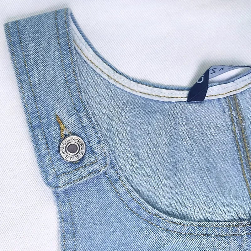 Model wearing the Dolores lightweight blue denim dress styled with casual summer accessories