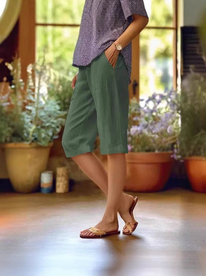 Flat lay of light summer shorts in multiple colors including white, beige, green, black, and light blue
