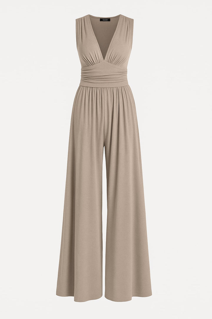 Side view of a woman wearing a navy wide-leg jumpsuit highlighting the defined waist and elongated leg line