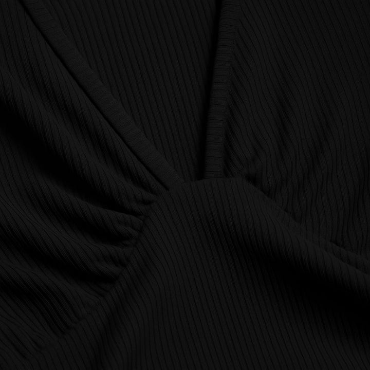 Blue wide-leg ribbed jumpsuit on a model showing the graceful drape of the wide-leg cut