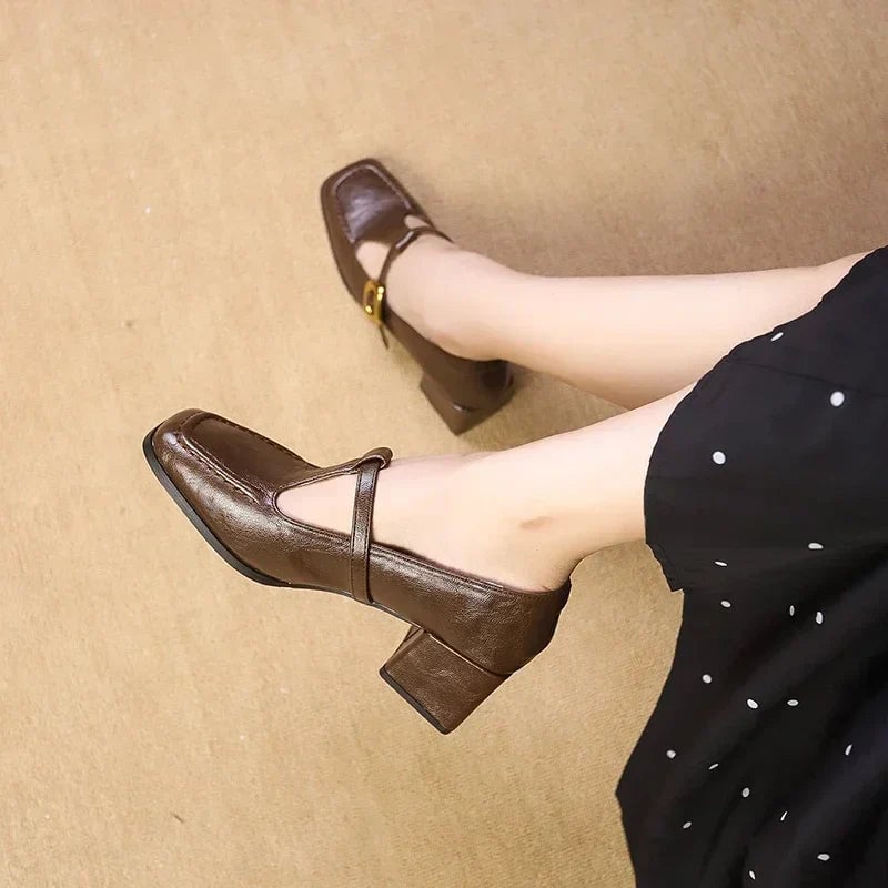 Close-up of gold-dotted buckle strap on Odette mary jane heels in brown croc-embossed leather