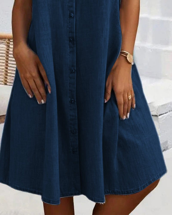 Flat lay of the lightweight denim-look dress showing fabric texture and button detail