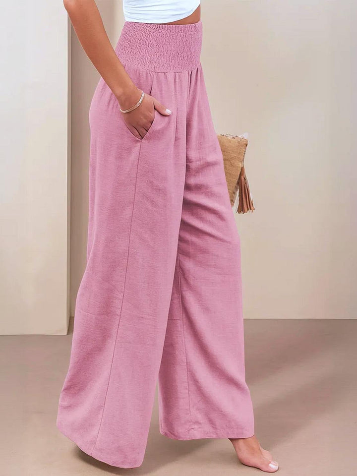 Close-up of front pleat detail on light pink wide leg pants
