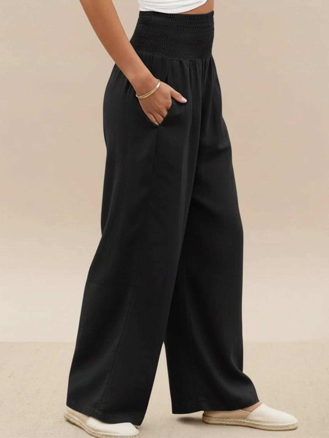 Model in black wide leg pants paired with pointed flats and a blouse