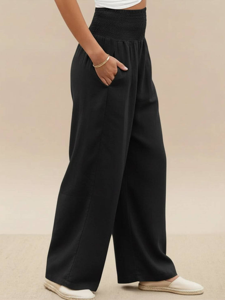 Model in black wide leg pants paired with pointed flats and a blouse