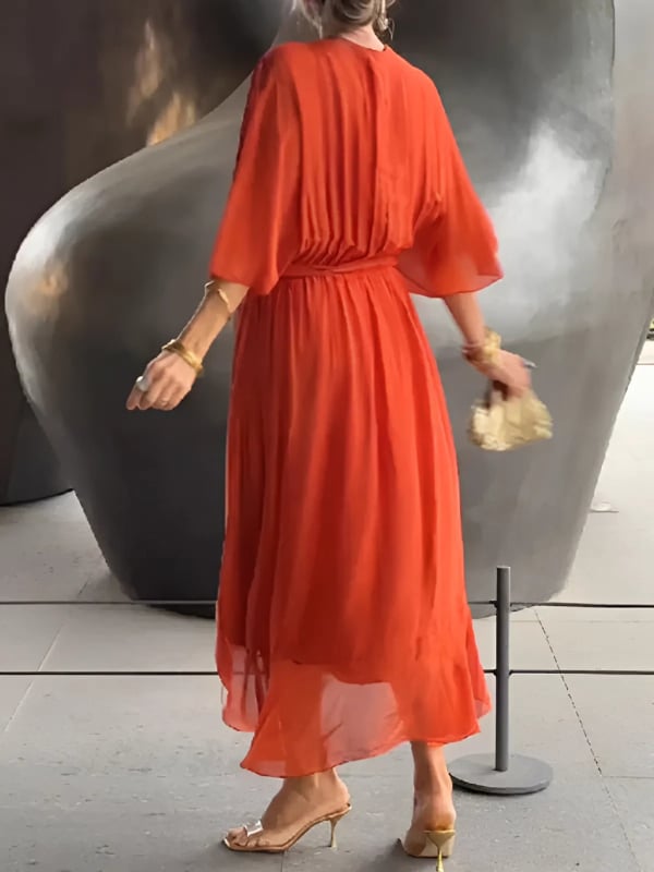 Lifestyle shot of woman wearing the Eden draped midi dress styled with heeled sandals for a polished look