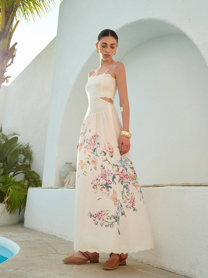 Woman wearing the Eden apricot floral maxi dress with cutout waist and scalloped hem, front view