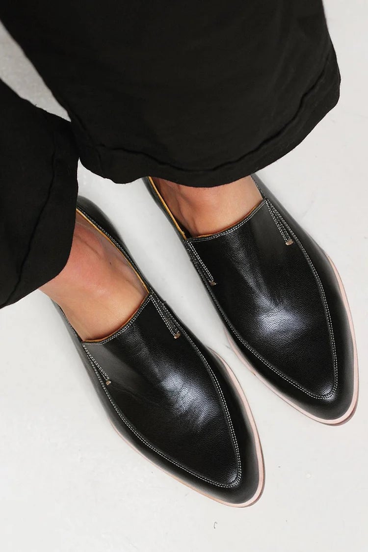 Front angle close-up of black minimalist loafers showing sleek toe and soft upper construction