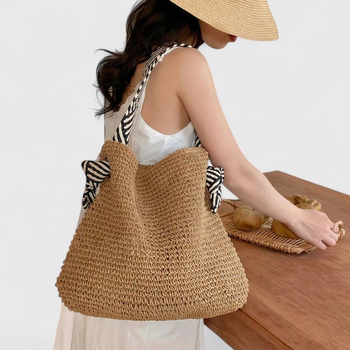 Natural beige woven shoulder bag with artisan patterned straps, front view