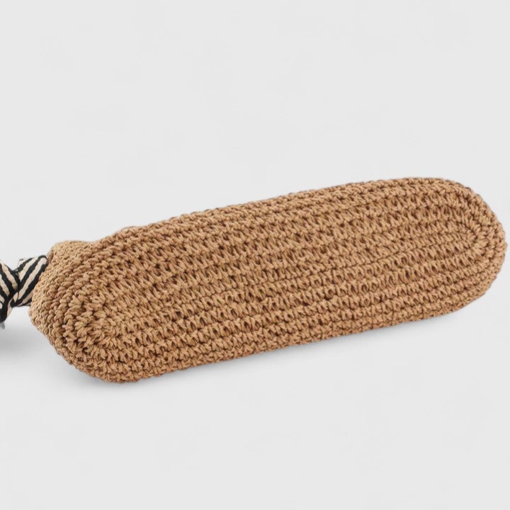 Overhead flat lay of natural beige braided shoulder bag on light surface