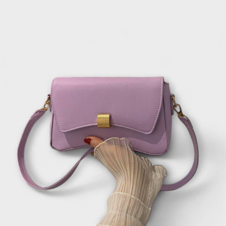 Model carrying the Elida shoulder bag in terracotta over one shoulder in a casual daytime outfit
