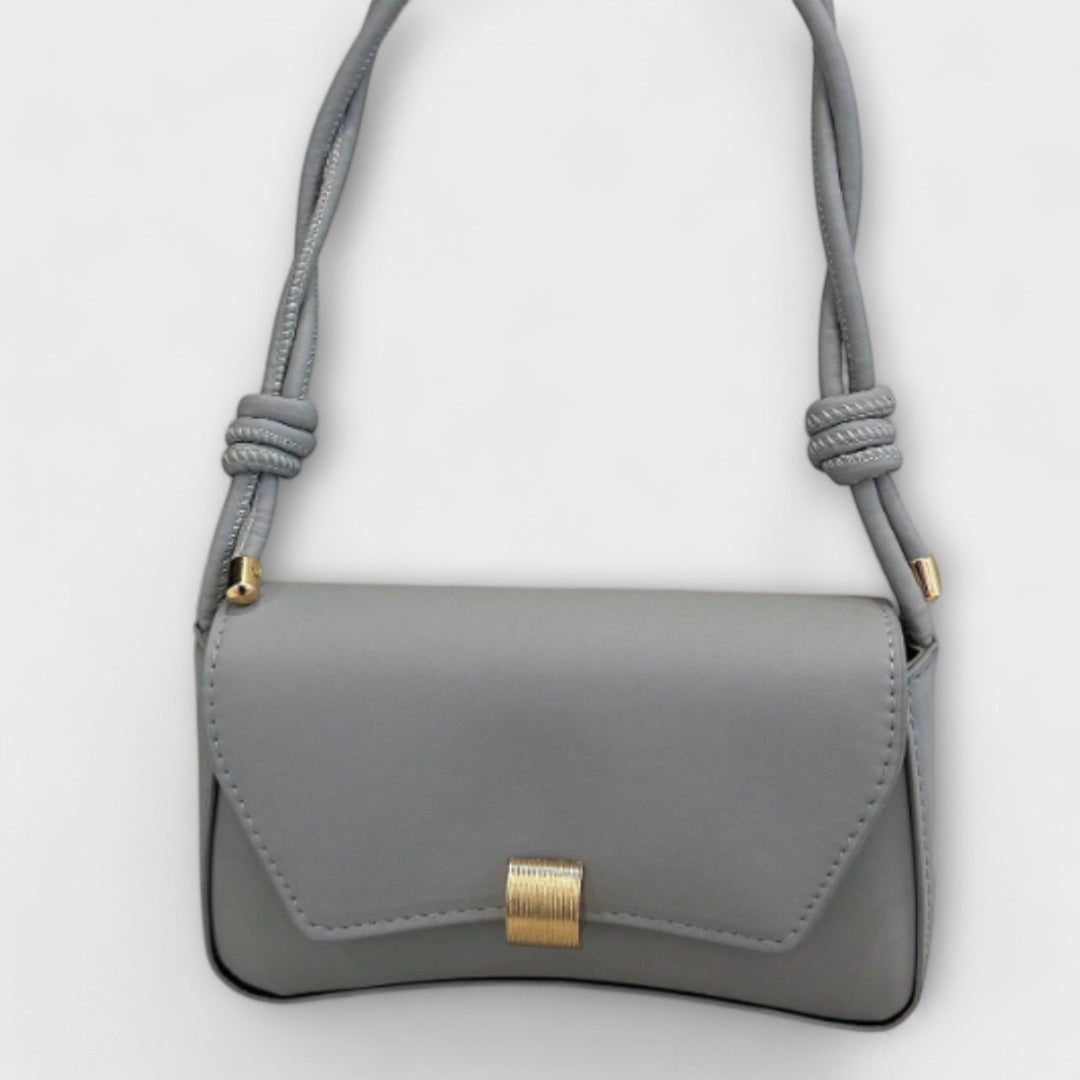 Elida shoulder bag in beige laid flat showing top zip closure and clean exterior