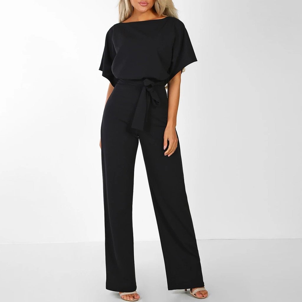 Close-up front view of a belted wide-leg jumpsuit in pink showing the adjustable waist belt and fluid fabric drape