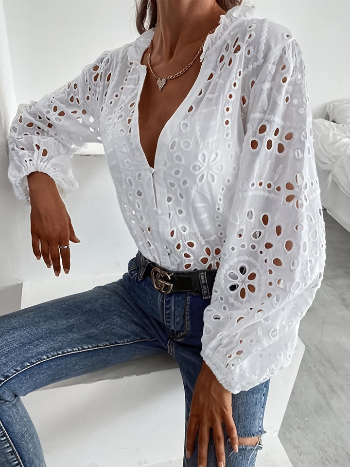 Detail shot of the neckline and embroidery on a white floral long-sleeve blouse