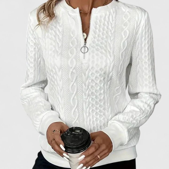 Woman wearing the Elise sophisticated sweater in black with a casual denim outfit