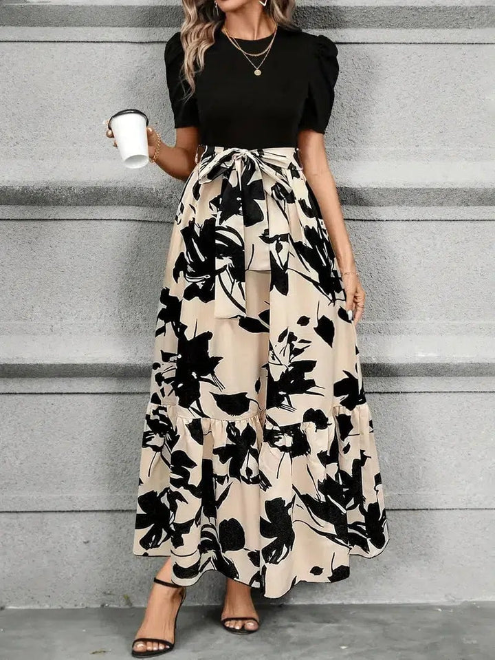 Woman in the Elise floral maxi dress in Olive Leaf Black styled for a summer occasion, full-length front view