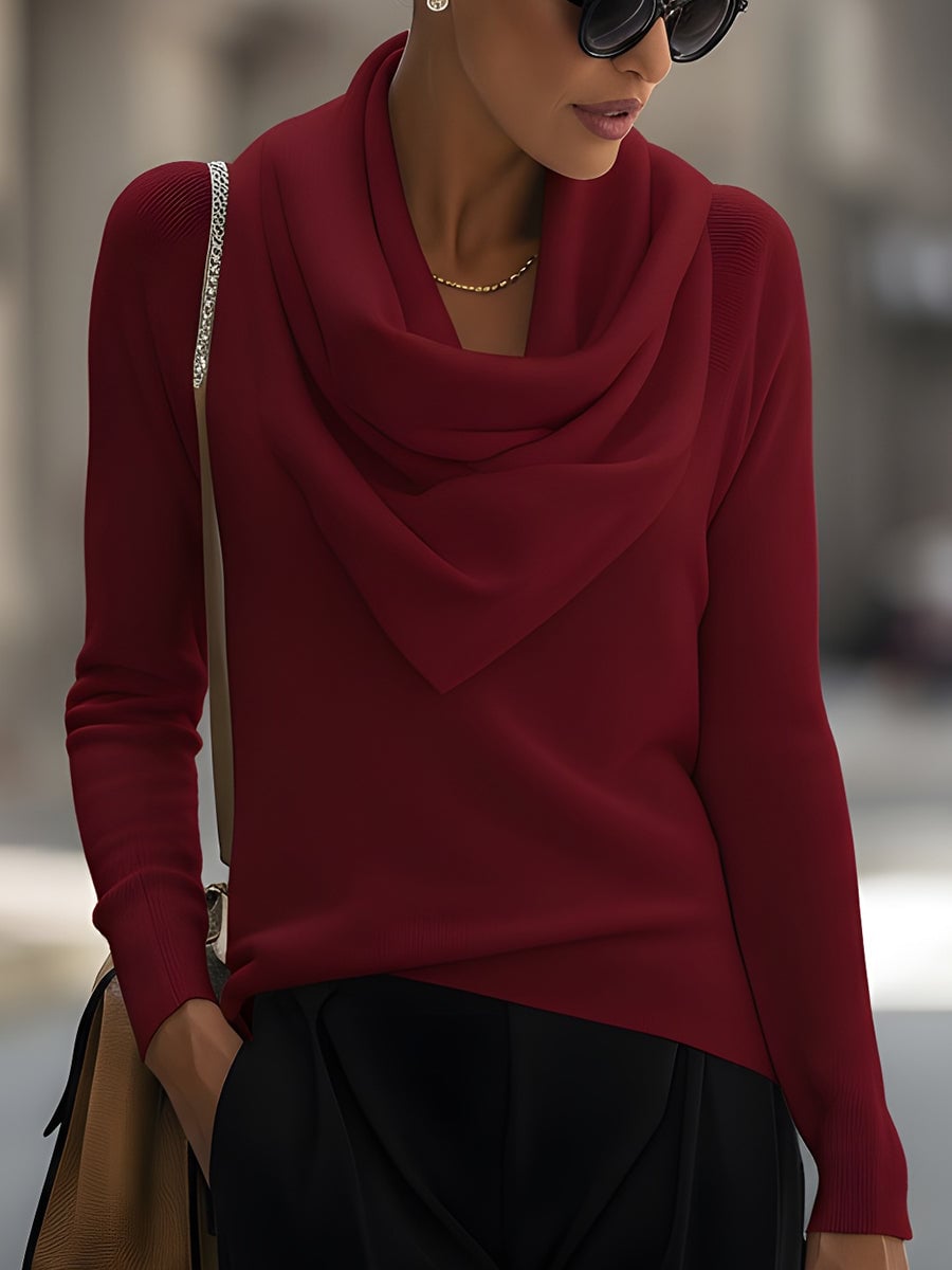 Model wearing a burgundy cowl neck long-sleeve top styled with high-waisted trousers