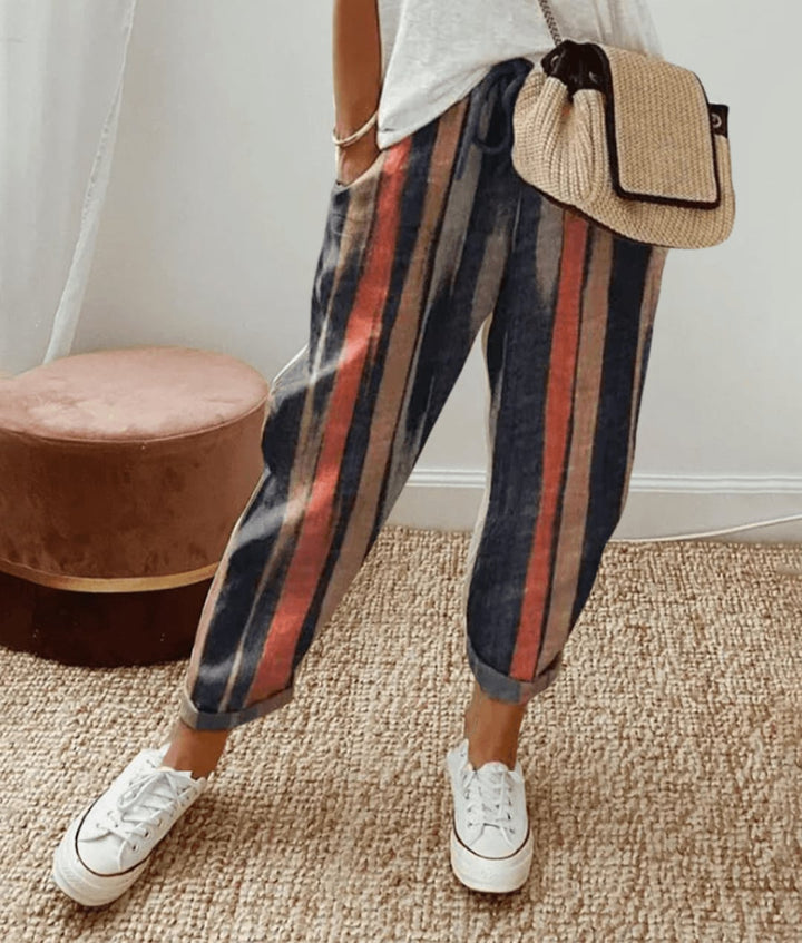 Woman wearing lightweight print trousers with a soft adjustable drawstring waistband in a flattering tapered silhouette