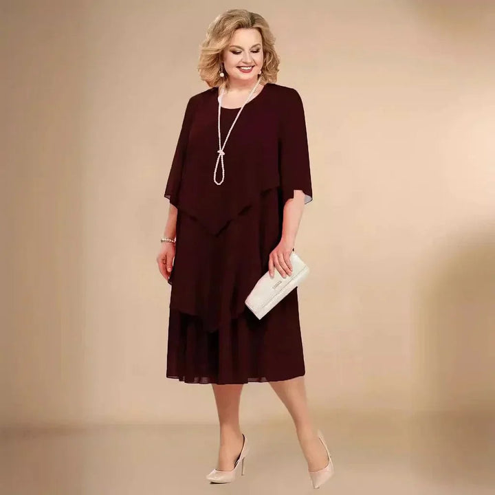 Model wearing Ellen chiffon dress in navy styled with heels for a formal occasion
