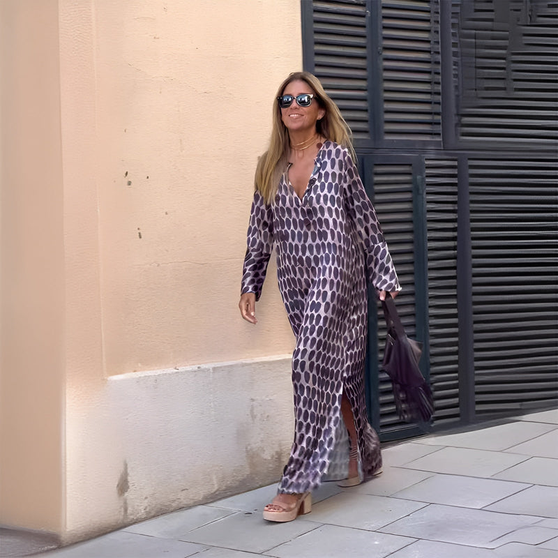 Woman wearing the Eloise flowy boho printed dress in purple, featuring a softly defined waist and lightweight flowing skirt