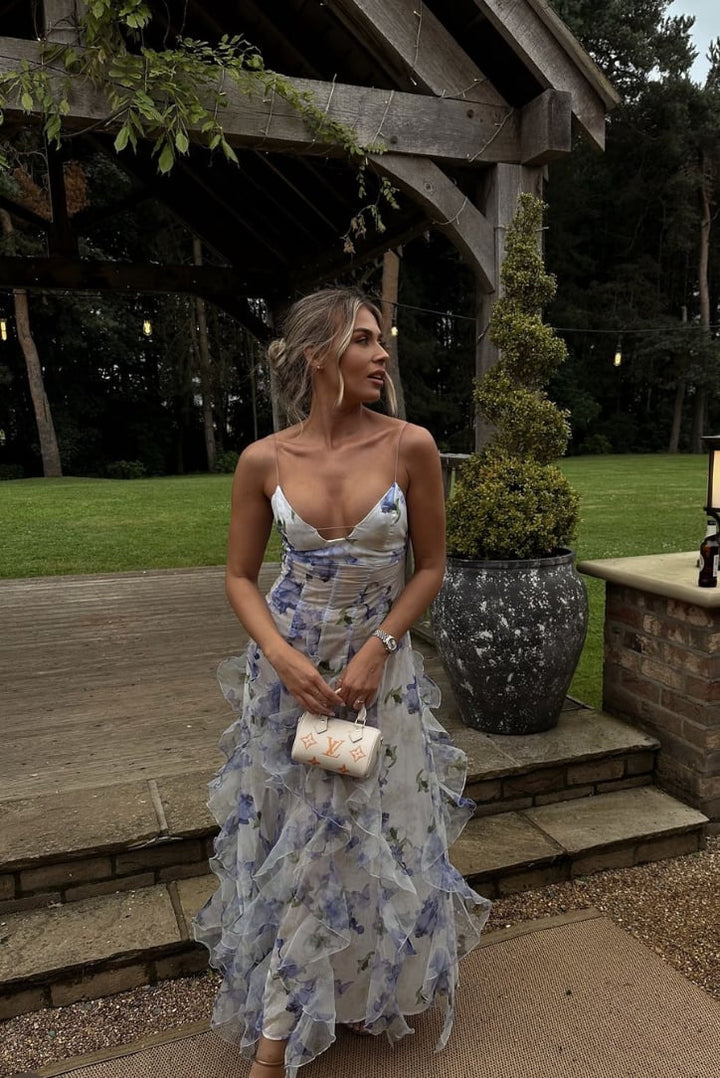 Woman in the Eloise blue maxi dress walking through an outdoor garden venue