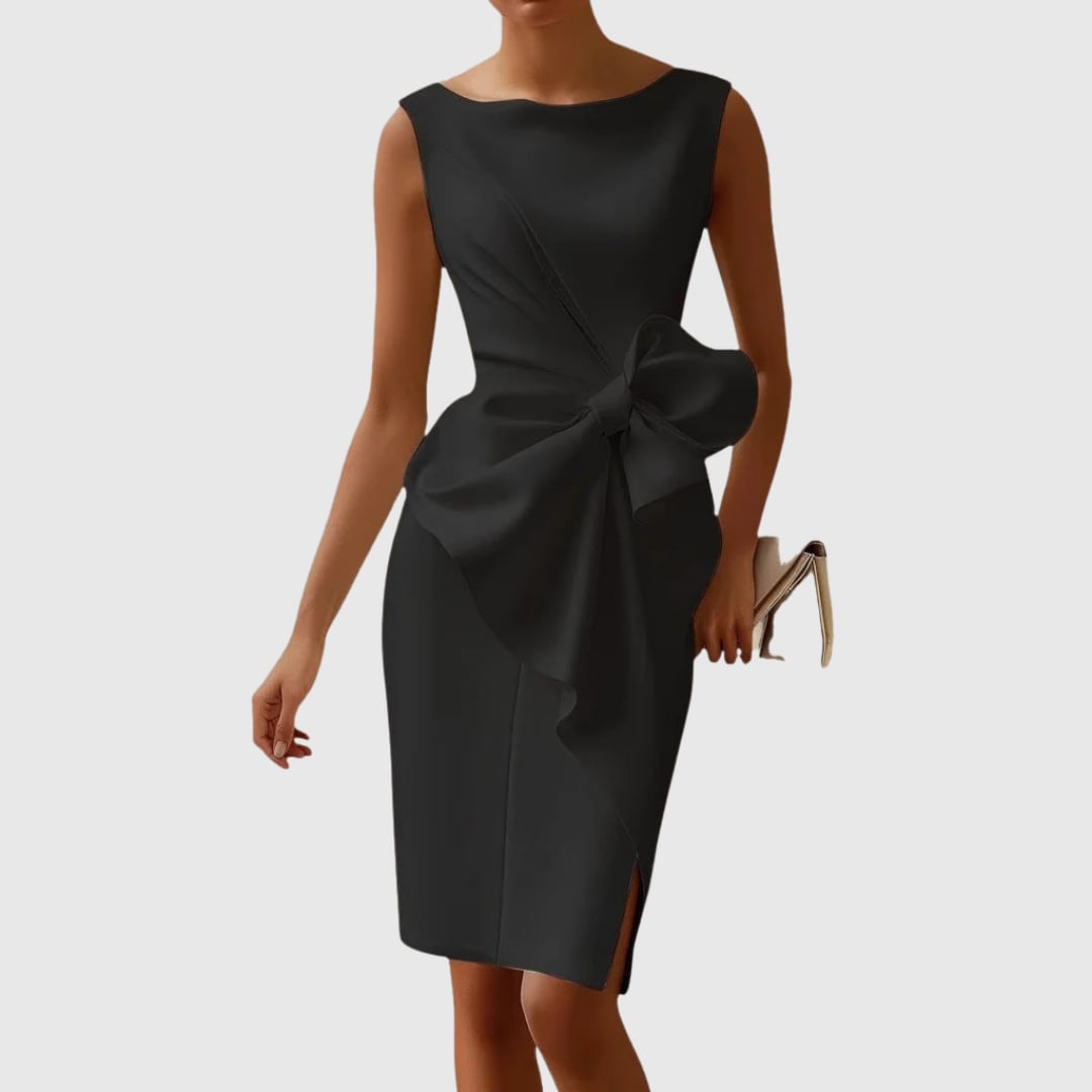 Woman wearing the Eloise sleeveless boat neck midi dress in black with a sculptural side bow at the hip and cascading front drape