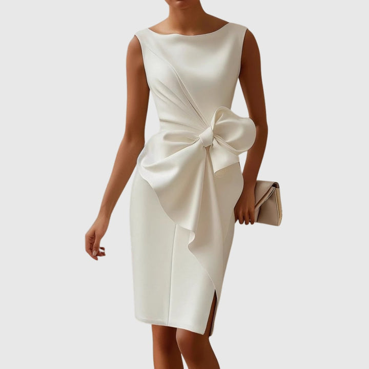 Full-length view of the Eloise bow midi dress showing the front hem slit and overall occasion-ready silhouette