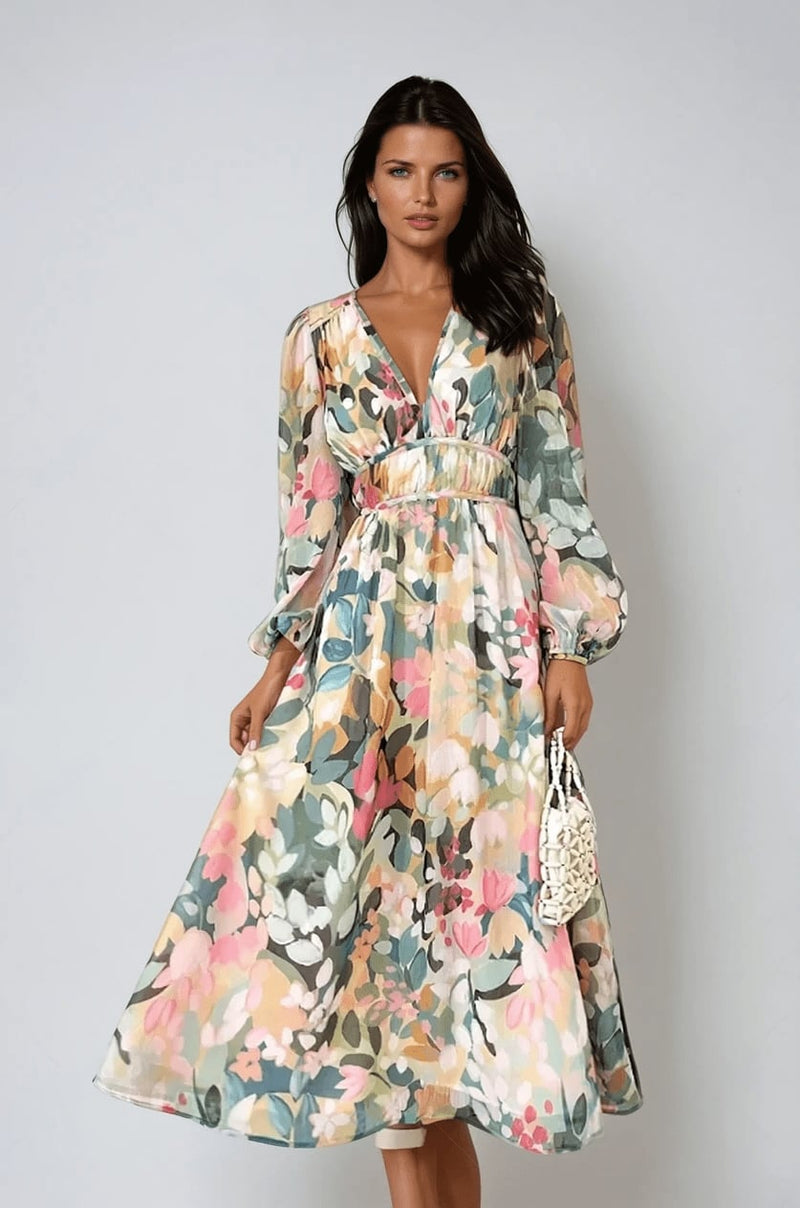 Woman wearing the Eloise floral midi dress in a multicolor watercolor print with a deep V-neckline, billowy long sleeves, and a flowing A-line skirt