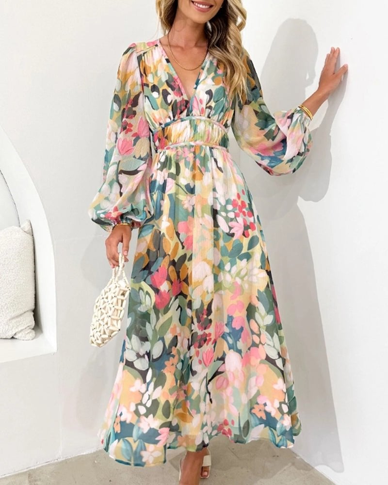 Back view of the Eloise floral midi dress showing the gathered long sleeves with cuffed hem and full A-line silhouette in blush, sage, and peach print