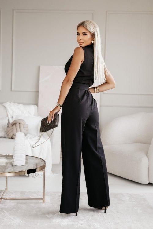 Woman wearing a khaki sleeveless wide-leg wrap jumpsuit with a deep V-neckline, front view