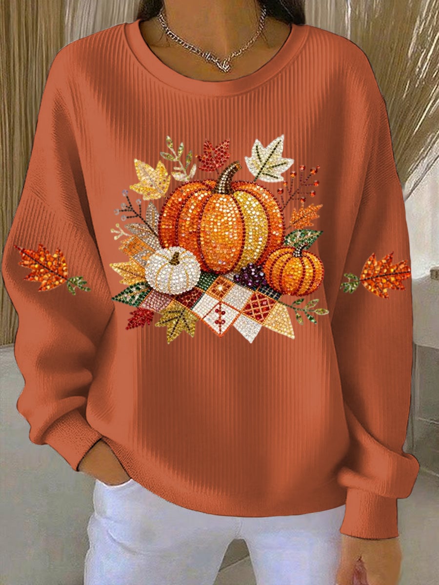Woman wearing an orange relaxed-fit harvest-print sweatshirt against a warm autumn background