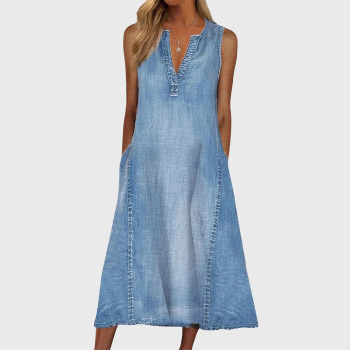 Woman wearing the Emerson blue denim flowy dress with a relaxed, elongating silhouette, styled with sandals