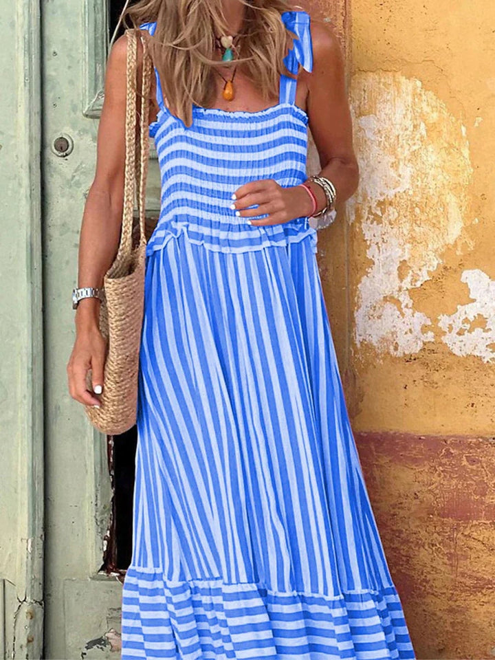 Woman in the Emilia pink striped dress styled with sandals for a casual summer brunch look