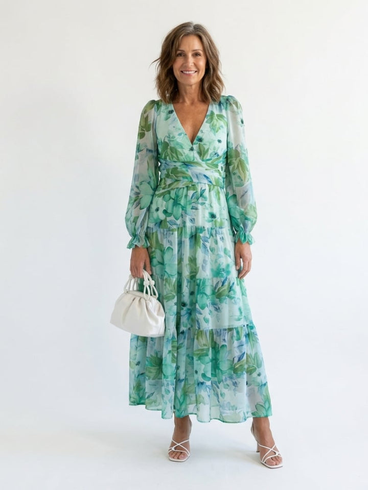 Woman wearing the Emilia green floral maxi dress with V-neckline and long sleeves, full-length front view