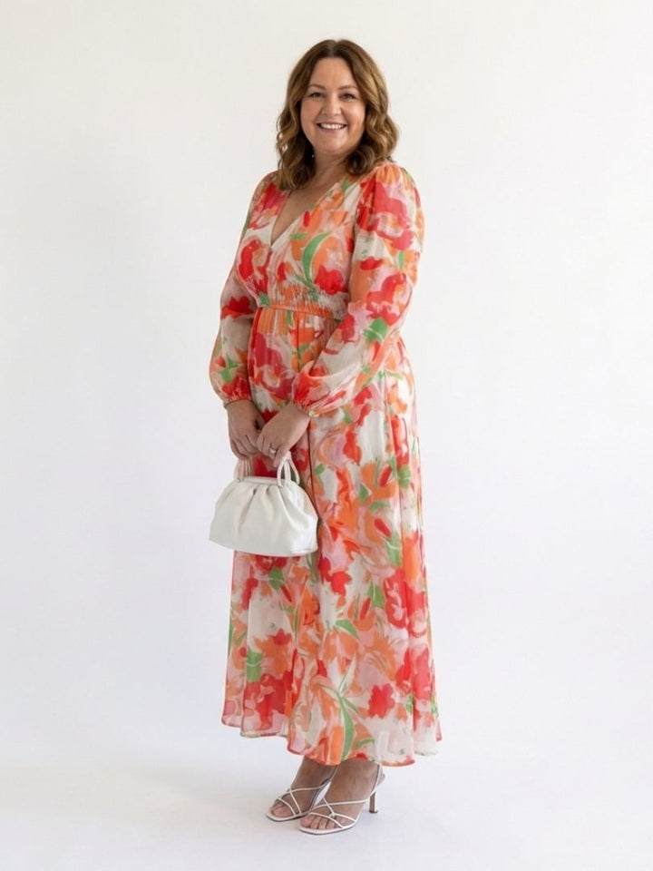 Close-up of the vibrant floral print on the Emilia maxi dress in orange