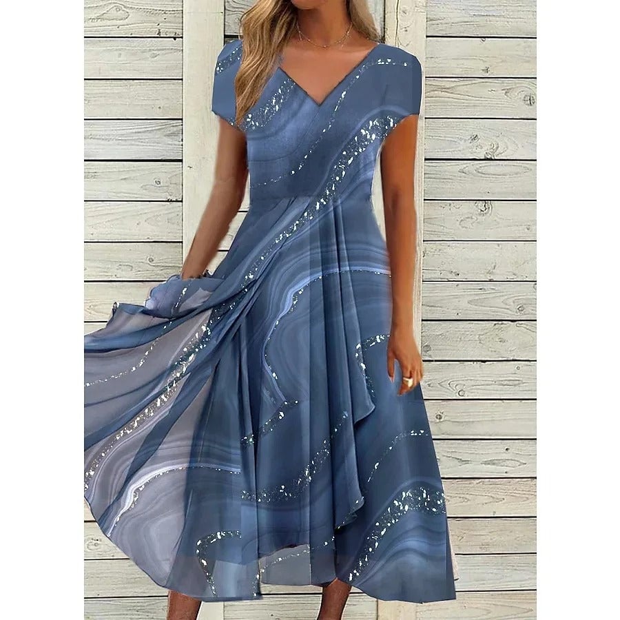 Woman wearing a flowing V-neck midi dress with subtle patchwork contrast panels in ocean blue