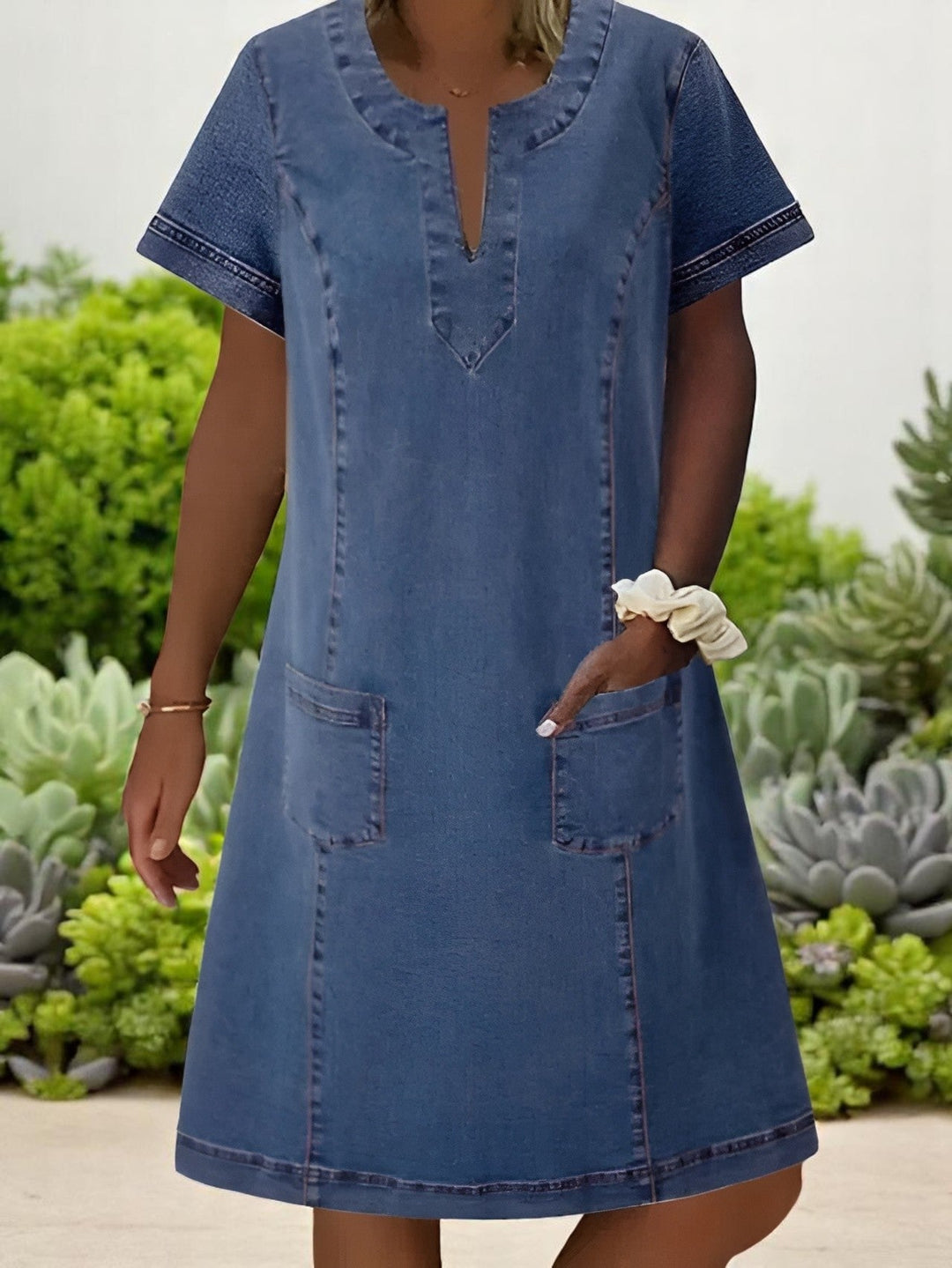 Woman wearing a relaxed-fit soft denim dress with front pockets, styled for a casual everyday look