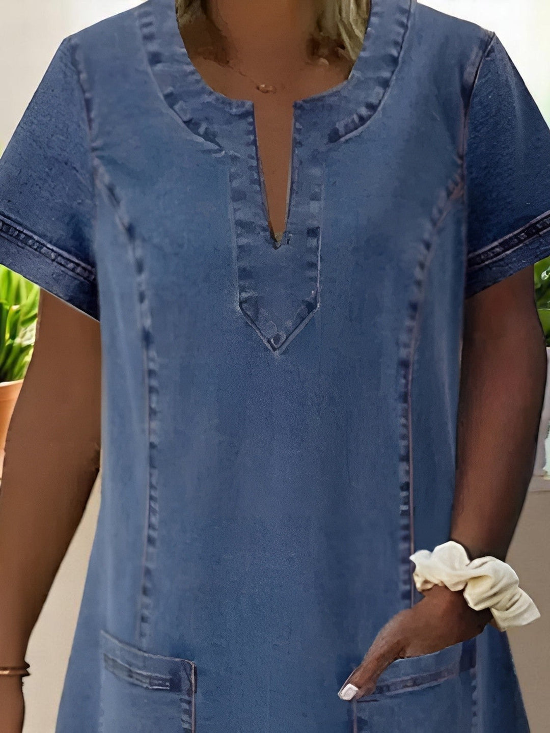 Front view of a lightweight soft denim dress showing functional pockets and easy silhouette