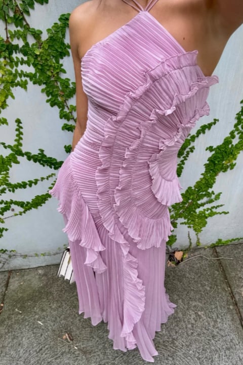 Side view of the Estelle halter dress showing cascading skirt movement and sculpted pleats