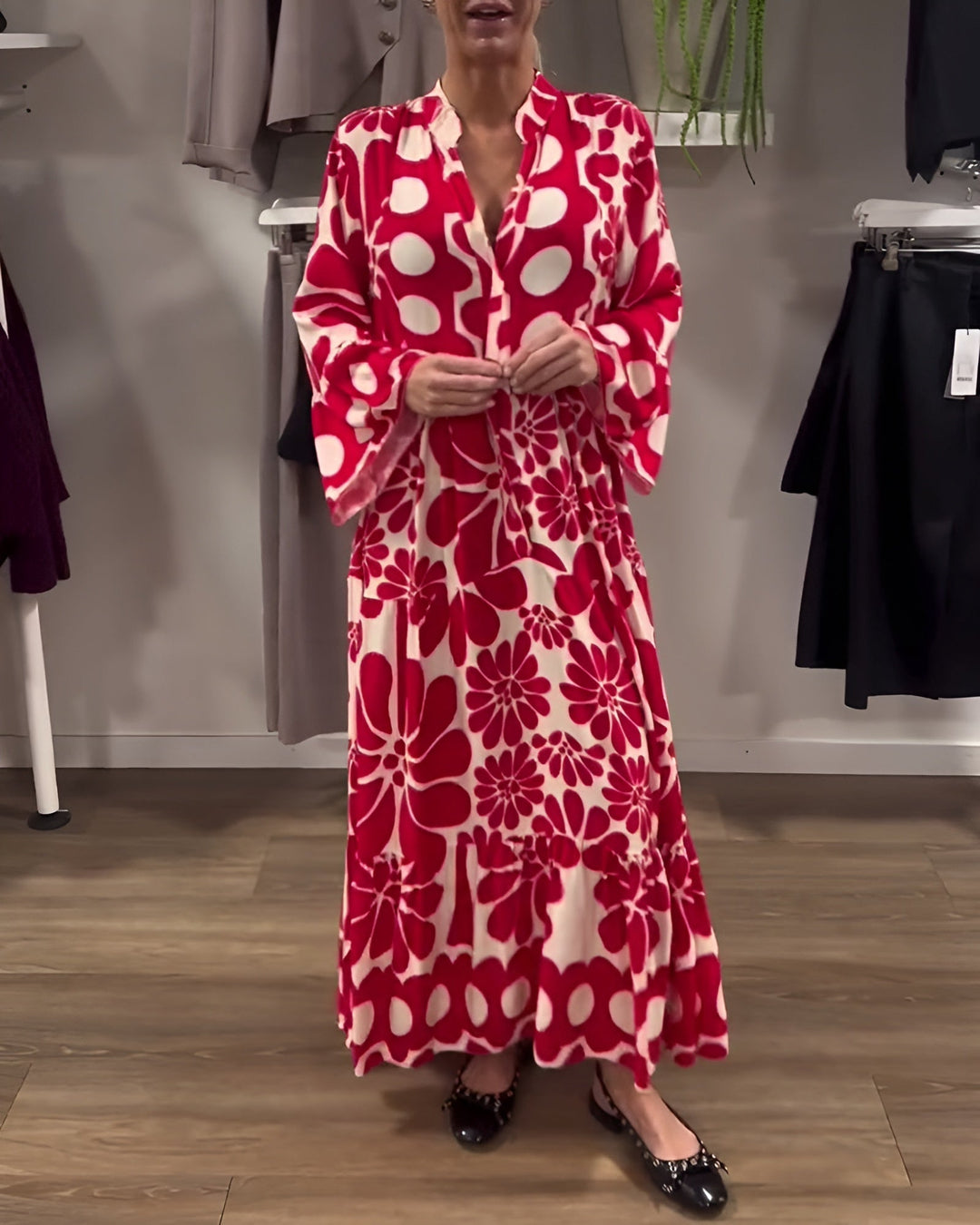 Woman wearing a red flowy printed draped maxi dress with tummy control silhouette, front view